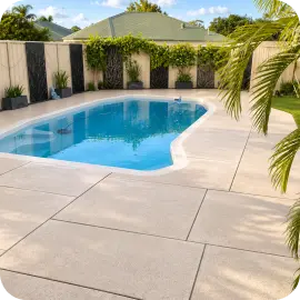 A pristine, freshly cleaned concrete pool deck surrounding clear blue water in a backyard.