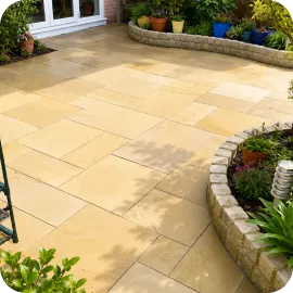 A beautifully clean, tan stone paver patio surrounded by curved garden retaining walls with potted plants.