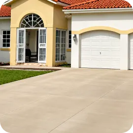 A smooth, clean concrete driveway surface leading up to a residential home with a white garage door, prepped and ready for sealing.